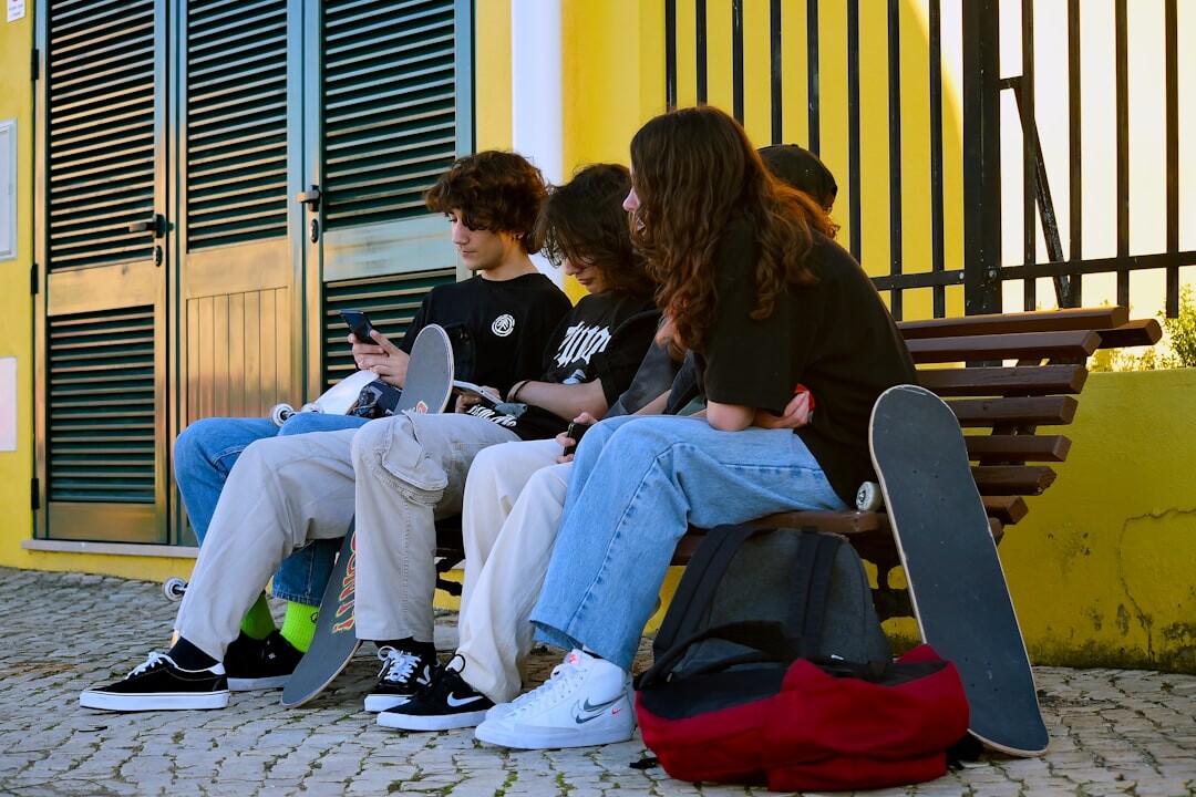 Teacher explaining media literacy to teenage students in a classroom with a projected news headline